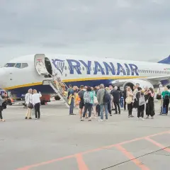 Pasażerowie wsiadają do samolotu Ryanair po schodkach.