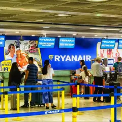 Odprawa na lotnisku Ryanair. Pasażerowie czekają w kolejce do stanowiska odprawy bagażu i biletów.