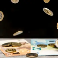 Monety euro spadają na banknoty 50 i 20 euro. To symboliczna scena pokazująca portugalia waluta w ruchu.