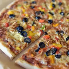 Kolorowa pizza z oliwkami, papryką i kurczakiem. Różne rodzaje pizzy mogą zawierać podobne, pyszne składniki.
