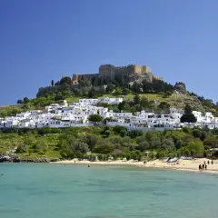 Majowa pogoda na Rodos zachwyca: białe domki Lindos, zamek na wzgórzu i turkusowe morze. Idealny czas na plażowanie.