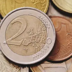 Zbliżenie na stos monet euro, w tym monety 2 euro i 5 centów.