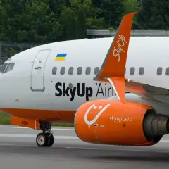 Samolot SkyUp Airlines z pomarańczowym silnikiem i charakterystycznym logo.