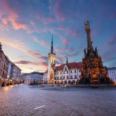 Zachód słońca nad pięknym rynkiem w Olomoucu, z widokiem na zabytkowy ratusz i Kolumnę Trójcy Świętej. Dolina Morawy wita o zmierzchu.