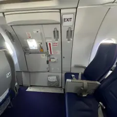 Wizz rozkład miejsc w samolocie Wizzair. Widok na rząd siedzeń i drzwi wyjściowe.