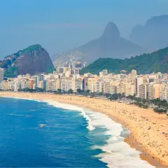 Copacabana w Rio de Janeiro, z tłumami na plaży i górami w tle. Zastanawiasz się, czy do Brazylii potrzebna jest wiza?