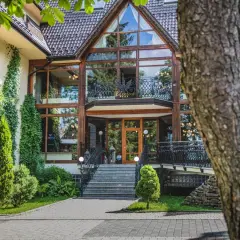 Elegancki hotel Belvedere Resort & Spa z imponującą szklaną fasadą, otoczony zielenią.