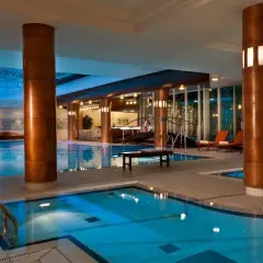 Basen hotelowy z leżakami i dekoracjami ściennymi.