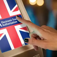 Palec dotyka ekranu z napisem "ETA Electronic Travel Authorization" i flagą Wielkiej Brytanii. Czy do Wielkiej Brytanii potrzebny jest paszport? Sprawdź ETA.