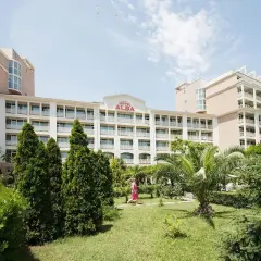 Hotel Alba w Bułgarii, z zielonym ogrodem i palmami. Słoneczny dzień zachęca do wypoczynku.