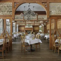 Elegancka restauracja w hotelu 5 gwiazdkowym, z drewnianymi zdobieniami i przytulnym kominkiem.