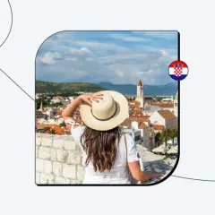 Kobieta w kapeluszu podziwia chorwackie miasto. Czy do Chorwacji potrzebny jest paszport? Sprawdź!