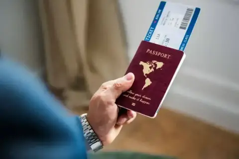 Dłoń trzyma paszport i bilet lotniczy. Czy Cypr jest w Schengen? Podróż marzeń czeka!