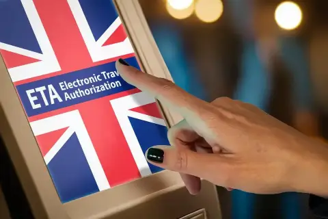 Palec dotyka ekranu z napisem "ETA Electronic Travel Authorization" i flagą Wielkiej Brytanii. Czy do Wielkiej Brytanii potrzebny jest paszport? Sprawdź ETA.