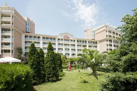 Hotel Alba w Bułgarii, z zielonym ogrodem i palmami. Słoneczny dzień zachęca do wypoczynku.