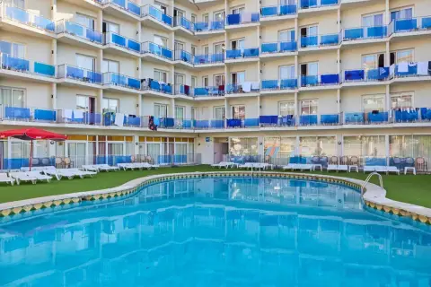 Basen i tarasy hotelu Don Juan Resort, z suszącym się praniem na balkonach.