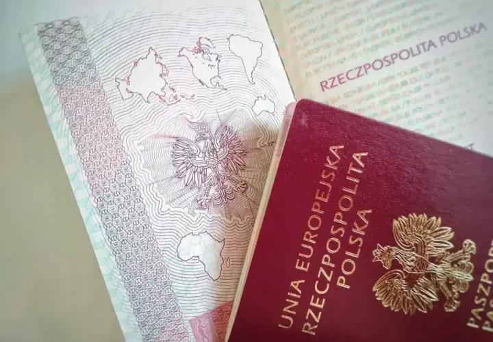 Polski paszport z godłem orła i mapą świata. Czy do Szwecji potrzebny jest paszport? Tak, jeśli podróżujesz spoza strefy Schengen.