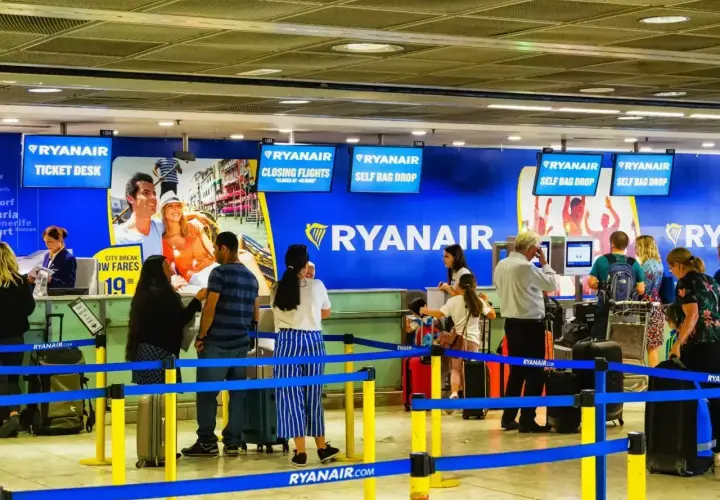 Odprawa na lotnisku Ryanair. Pasażerowie czekają w kolejce do stanowiska odprawy bagażu i biletów.