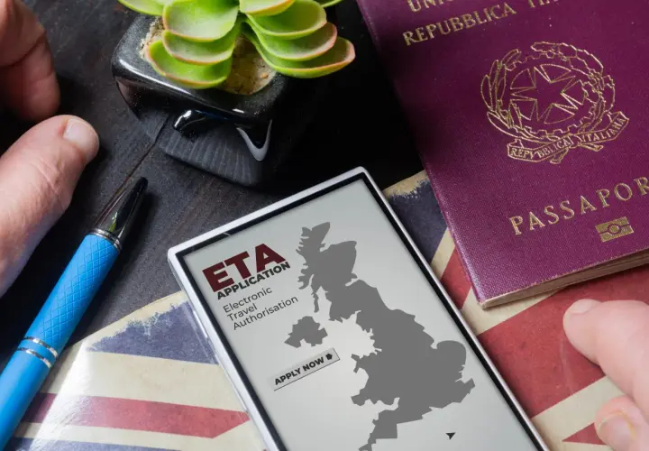 Telefon z mapą Wielkiej Brytanii i napisem "ETA APPLICATION" obok paszportu. Planujesz podróż do Londynu?