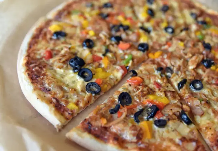 Kolorowa pizza z oliwkami, papryką i kurczakiem. Różne rodzaje pizzy mogą zawierać podobne, pyszne składniki.