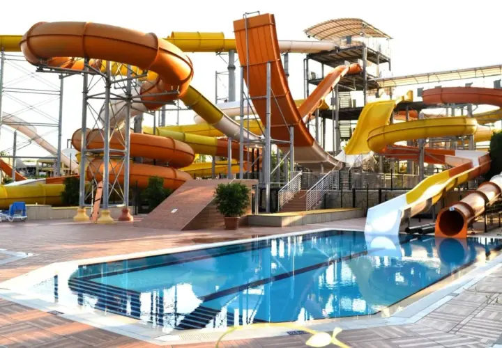 Wodny park rozrywki w Turcji, idealny na upalną pogodę w sierpniu. Kolorowe zjeżdżalnie i basen zapraszają do zabawy.
