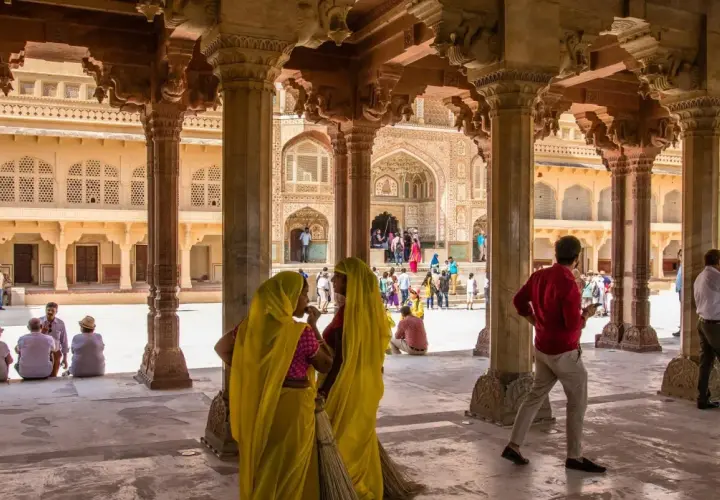 Wspaniała wycieczka do Indii! Widać tu dziedziniec z kolumnadą, turystów i kobiety w sari.