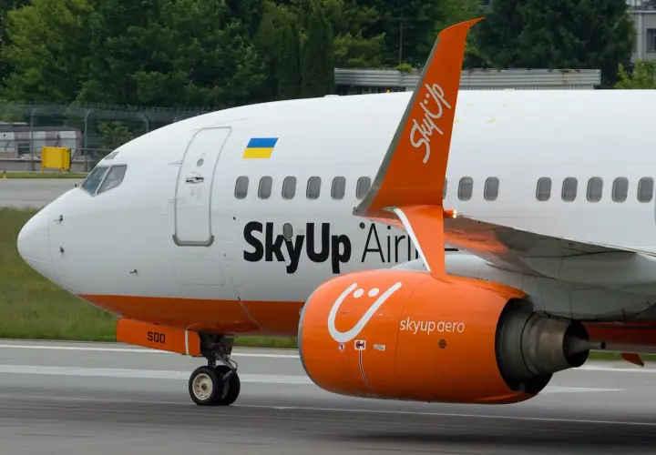 Samolot SkyUp Airlines z pomarańczowym silnikiem i charakterystycznym logo.