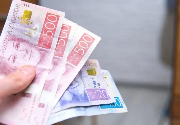 Dłoń trzyma banknoty 500 koron szwedzkich. To właśnie ta waluta obowiązuje w Szwecji.