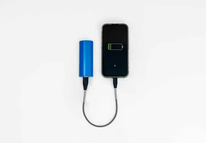 Niebieski powerbank Wizzair ładuje smartfon.