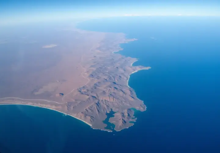 Widok z lotu ptaka na górzyste wybrzeże i ocean. Takie krajobrazy pomagają zrozumieć, gdzie leży Madagaskar.