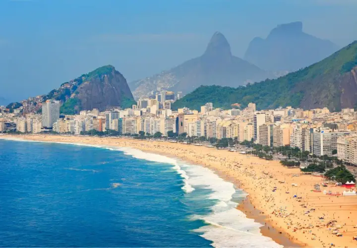 Copacabana w Rio de Janeiro, z tłumami na plaży i górami w tle. Zastanawiasz się, czy do Brazylii potrzebna jest wiza?