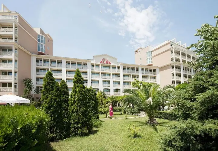Hotel Alba w Bułgarii, z zielonym ogrodem i palmami. Słoneczny dzień zachęca do wypoczynku.