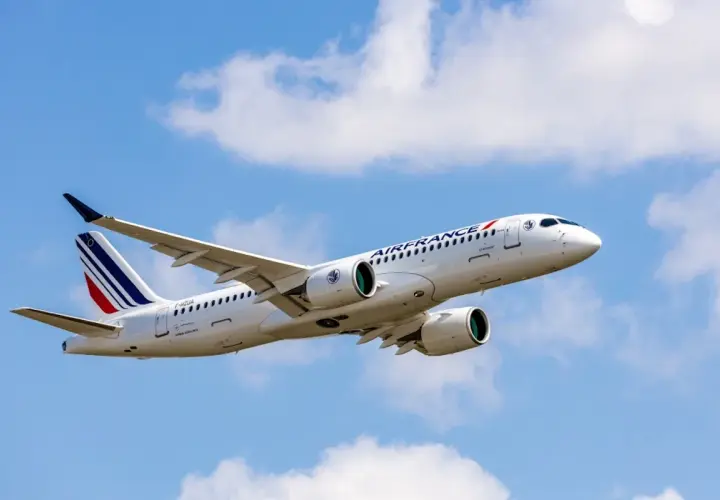 Airbus A220-300 linii Air France wzbija się w błękitne niebo z białymi chmurami.