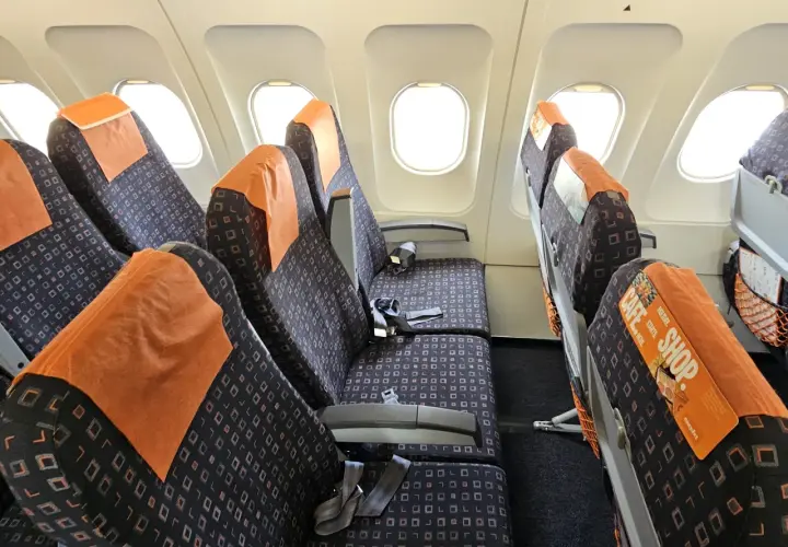 Puste siedzenia w samolocie easyJet, gotowe na pasażerów po odprawie online.