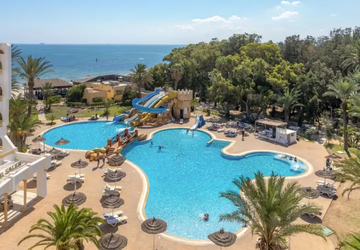 Basen z wodnymi zjeżdżalniami i palmami przy hotelu Marhaba Royal Salem.