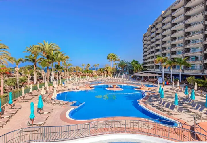 Luksusowy hotel z basenem i palmami, idealne miejsce na wakacje nad morzem. Anfi del Mar zaprasza!