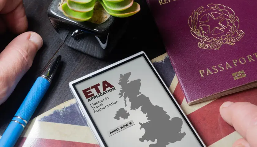 Telefon z mapą Wielkiej Brytanii i napisem "ETA APPLICATION" obok paszportu. Planujesz podróż do Londynu?