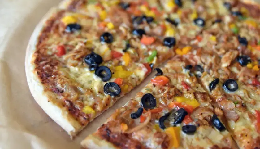 Kolorowa pizza z oliwkami, papryką i kurczakiem. Różne rodzaje pizzy mogą zawierać podobne, pyszne składniki.