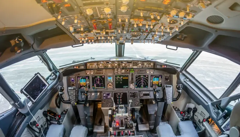 Kokpit samolotu a320neo. Widok z fotela pilota na zaawansowane przyrządy, ekrany i dźwignie sterowania.