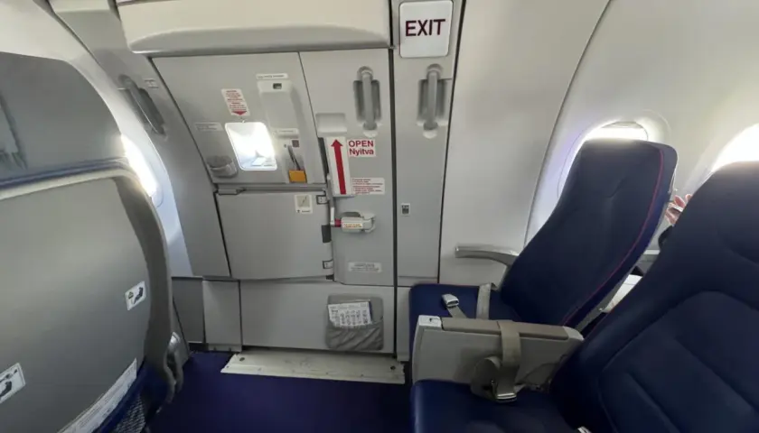 Wizz rozkład miejsc w samolocie Wizzair. Widok na rząd siedzeń i drzwi wyjściowe.