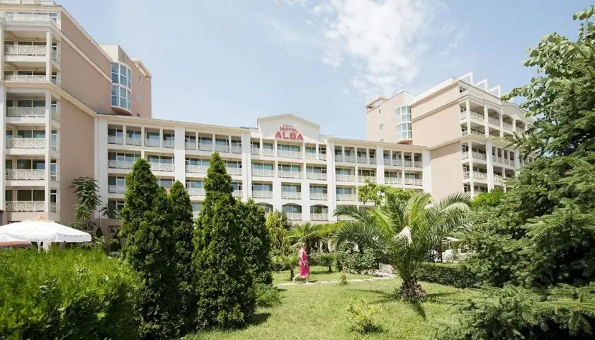 Hotel Alba w Bułgarii, z zielonym ogrodem i palmami. Słoneczny dzień zachęca do wypoczynku.