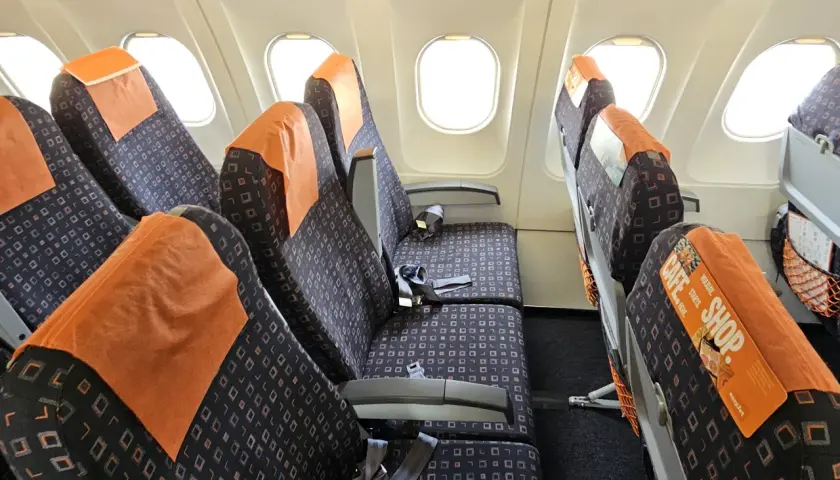 Puste siedzenia w samolocie easyJet, gotowe na pasażerów po odprawie online.