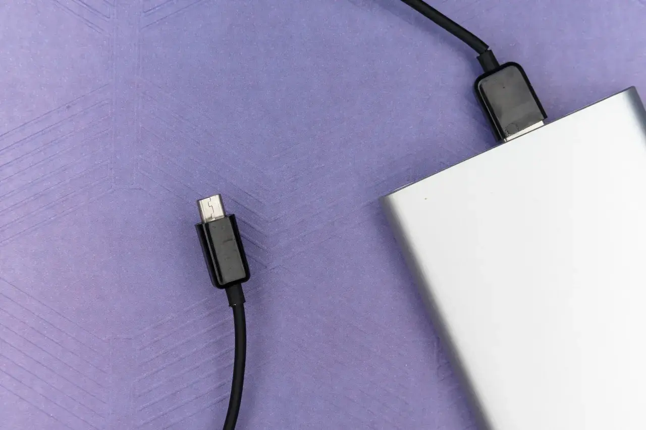 Srebrny powerbank, niezbędny w bagażu podręcznym, gotowy do ładowania urządzeń w podróży.