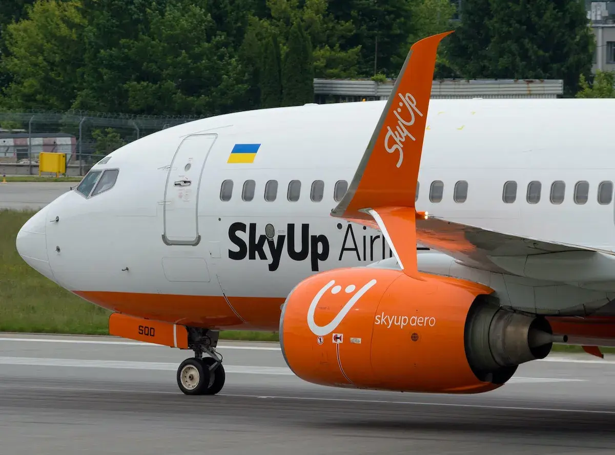 Samolot SkyUp Airlines z pomarańczowym silnikiem i charakterystycznym logo.