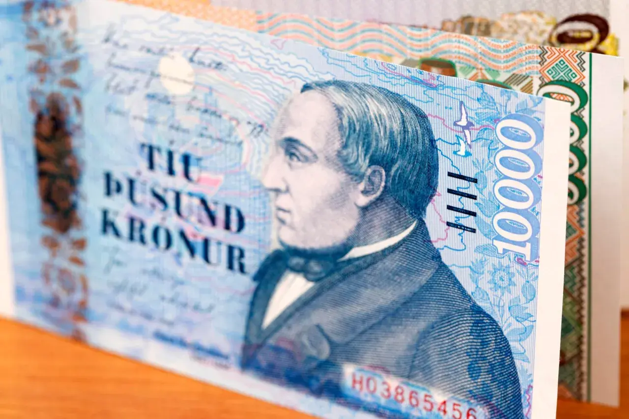 Fragment banknotu 10 000 koron islandzkich. Widoczny portret mężczyzny i cyfra 10000.