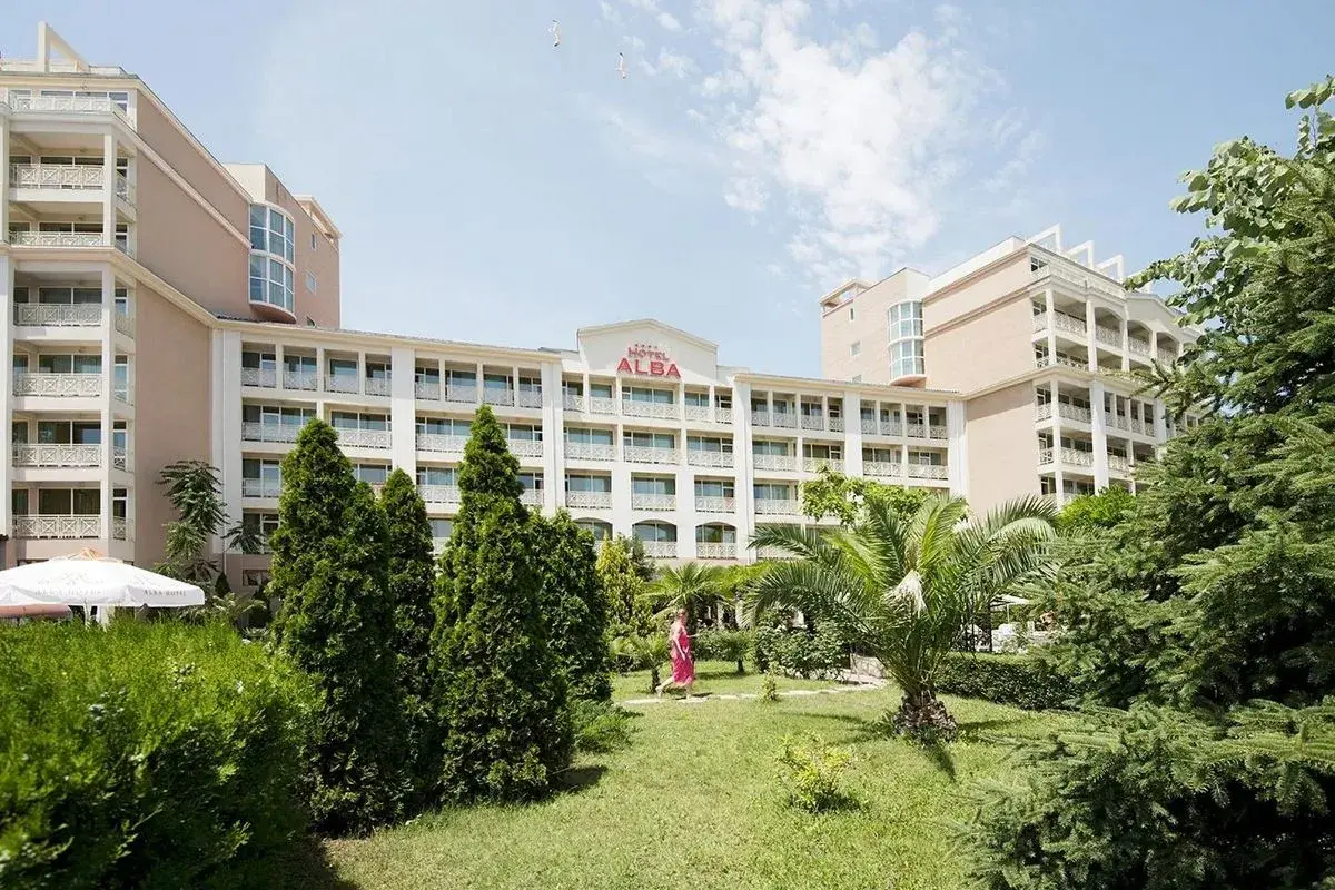 Hotel Alba w Bułgarii, z zielonym ogrodem i palmami. Słoneczny dzień zachęca do wypoczynku.