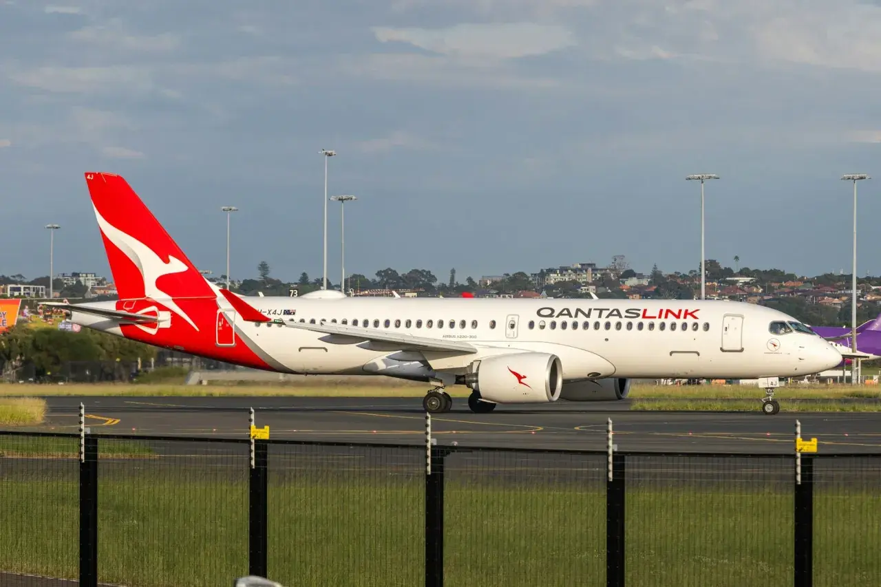 Airbus A321neo QantasLink na płycie lotniska, z charakterystycznym czerwonym ogonem i logo.