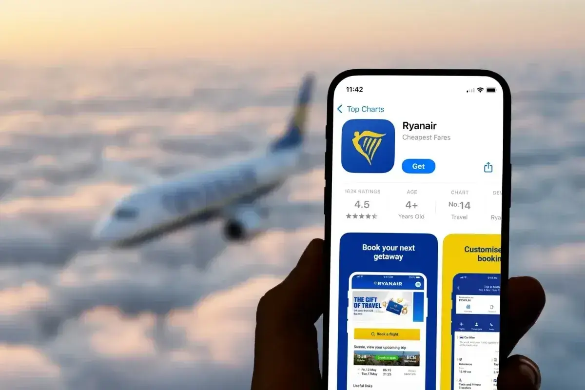 Aplikacja Ryanair na telefonie, z samolotem w tle. Czy Ryanair jest bezpieczny? Aplikacja ma ocenę 4.5 gwiazdki.