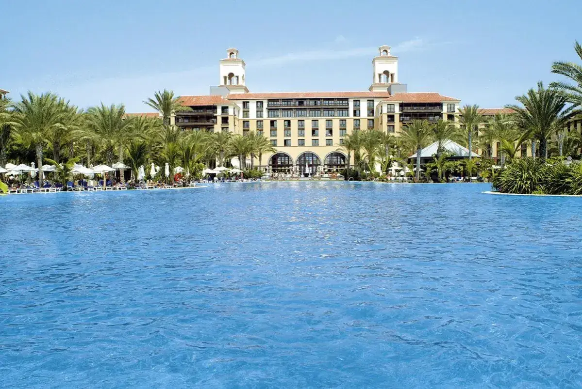 Luksusowy hotel z basenem i palmami w Meloneras. Idealne miejsce na wakacje.