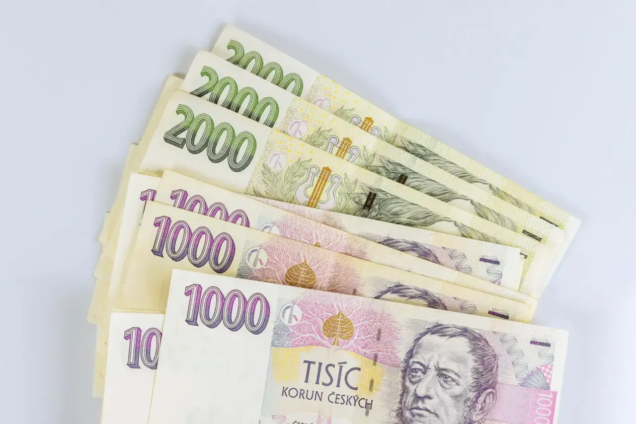 Kupka banknotów 1000 i 2000 koron czeskich, waluta w Czechach, leży na białym tle.